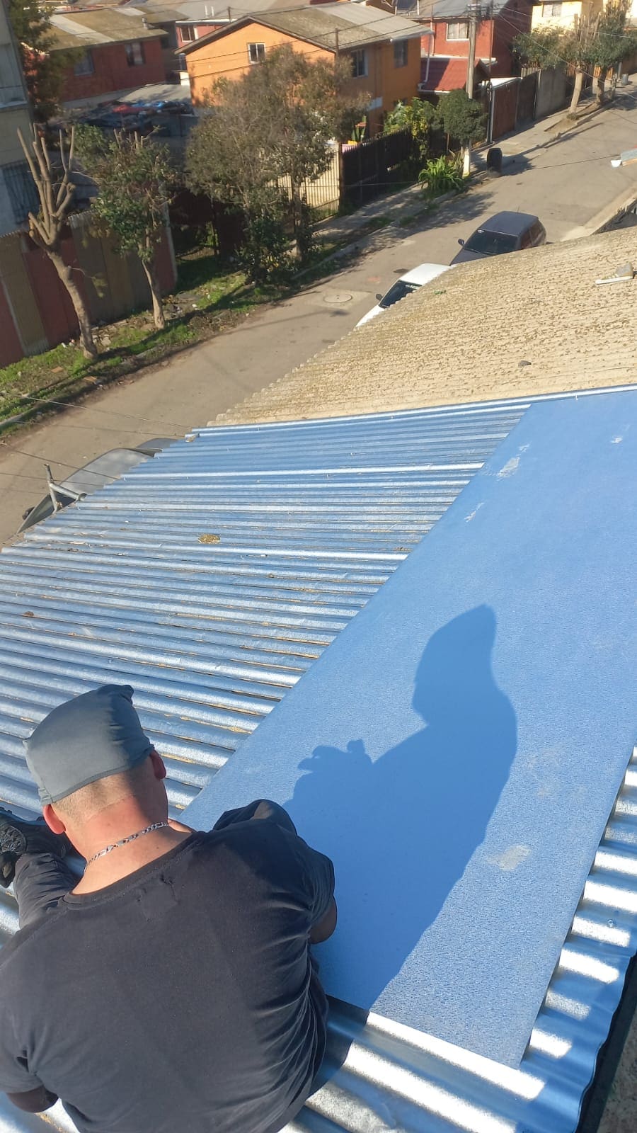 Maestro revisando terminación de techumbre de zinc color azul