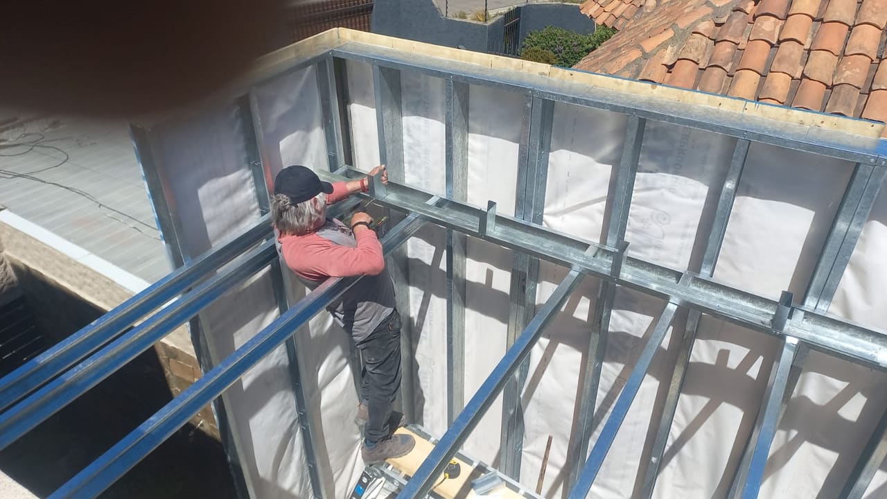Maestro instalando perfiles de steel framing en ampliación de vivienda