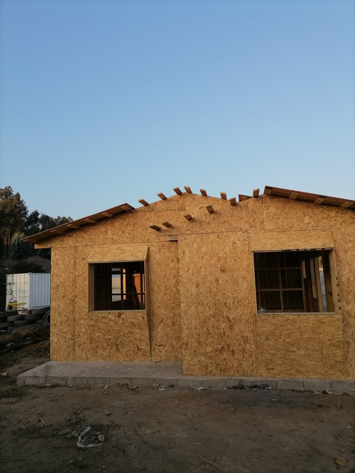 Vista lateral de casa en madera con dos cuerpos de techumbre terminados
