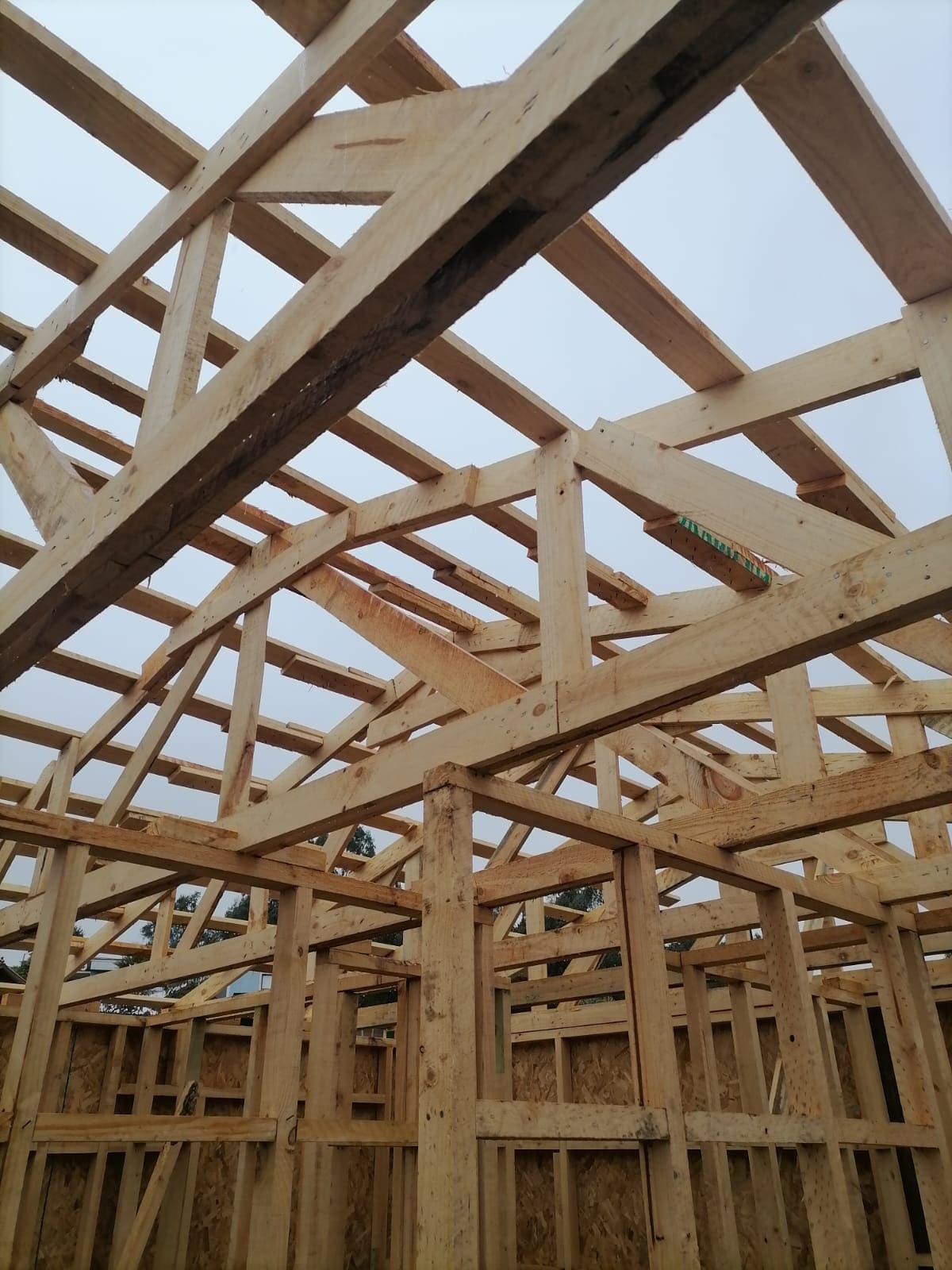 Detalle de estructura de techumbre en madera, cerchas y vigas entrecruzadas