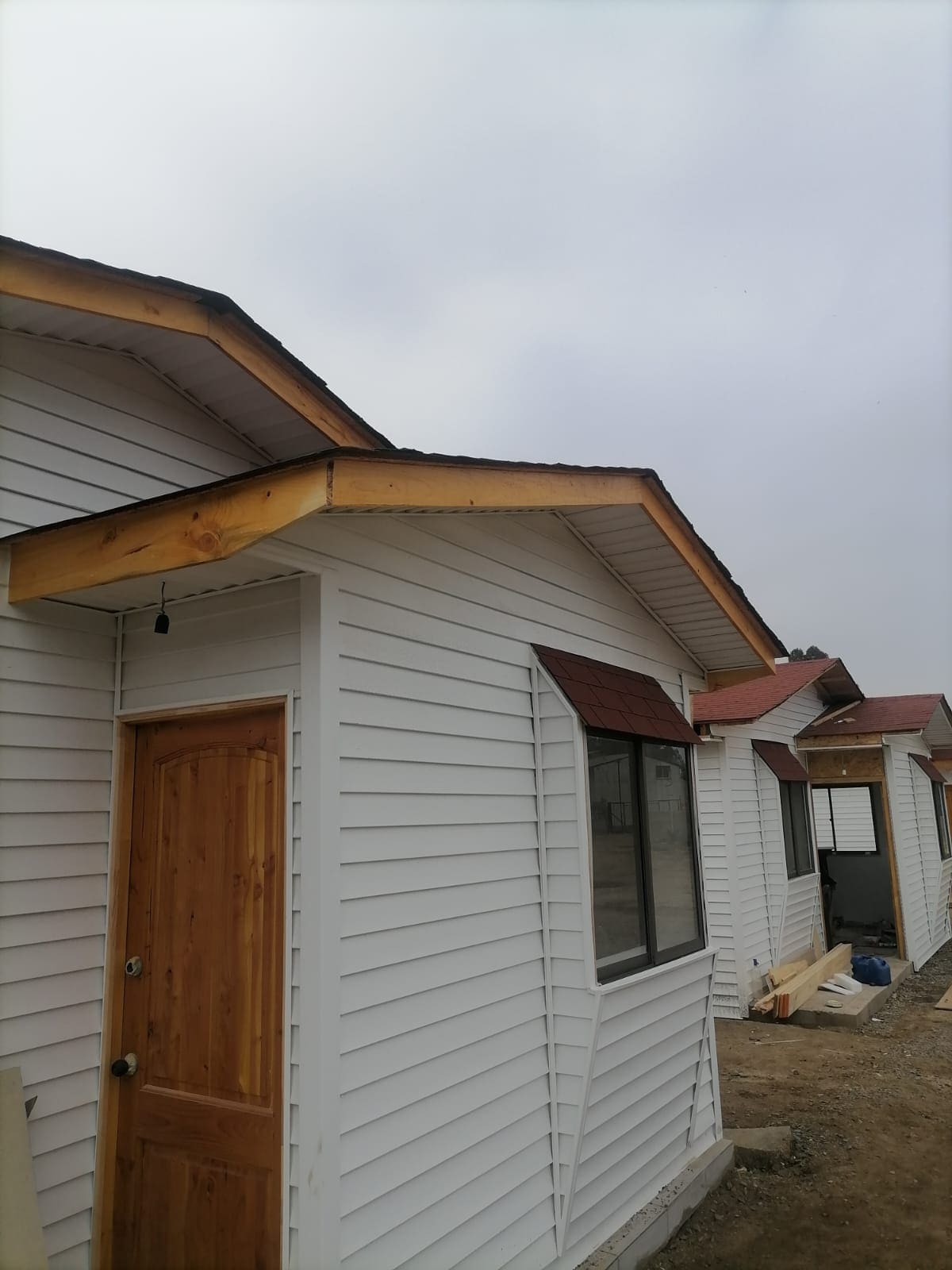 Fachada con siding vinílico blanco y ventanas ya instaladas
